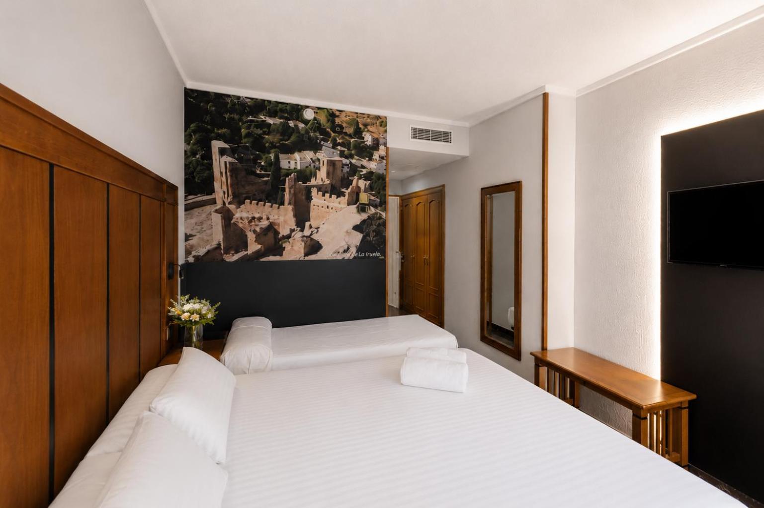 Habitación con cama extragrande y cama supletoria